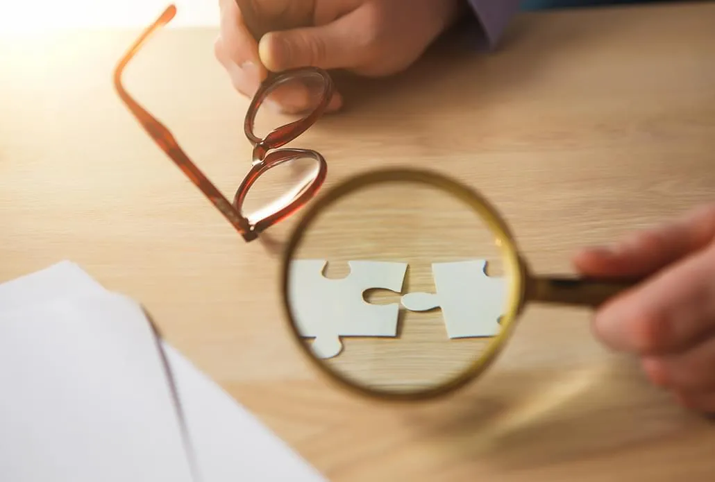 Une loupe examine deux pièces de puzzle assemblées