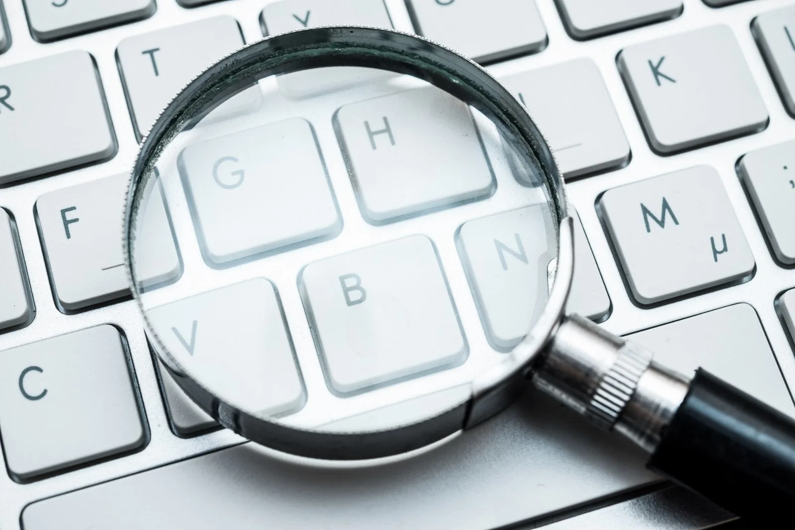 Loupe posée sur un clavier d’ordinateur